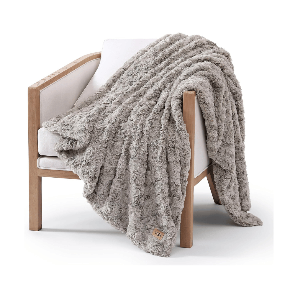 UGG Adalee Faux Fur Throw Blanket on wooden chair showing plush faux fur texture (Credit: MyRadiantSleep.com)