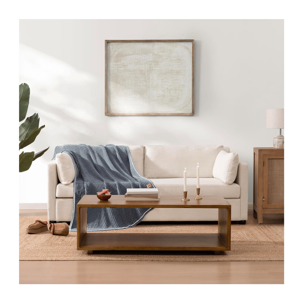 UGG Luna Knit Throw Blanket on sofa in living room (Credit: UGG / Amazon)