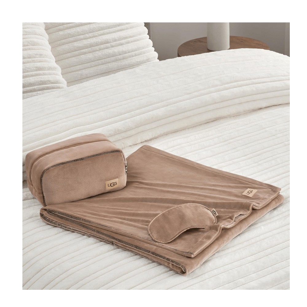 UGG Reagan Travel Set with blanket and mask displayed on bed (Credit: UGG / Amazon)