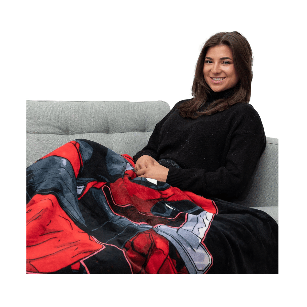 Marvel Deadpool raschel throw blanket draped on couch with red-black comic design”