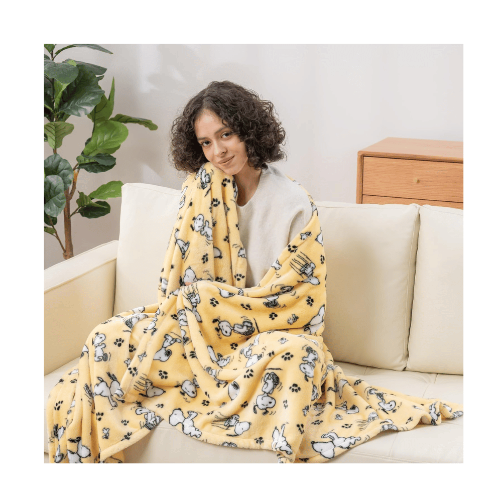 Berkshire VelvetLoft Peanuts Snoopy plush throw blanket draped across cozy bed for collectors