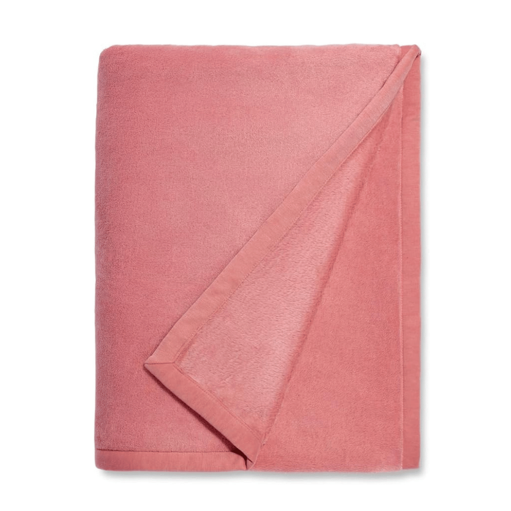 Folded blush pink UGG Duffield Throw II blanket with soft texture (Credit: UGG / Amazon)