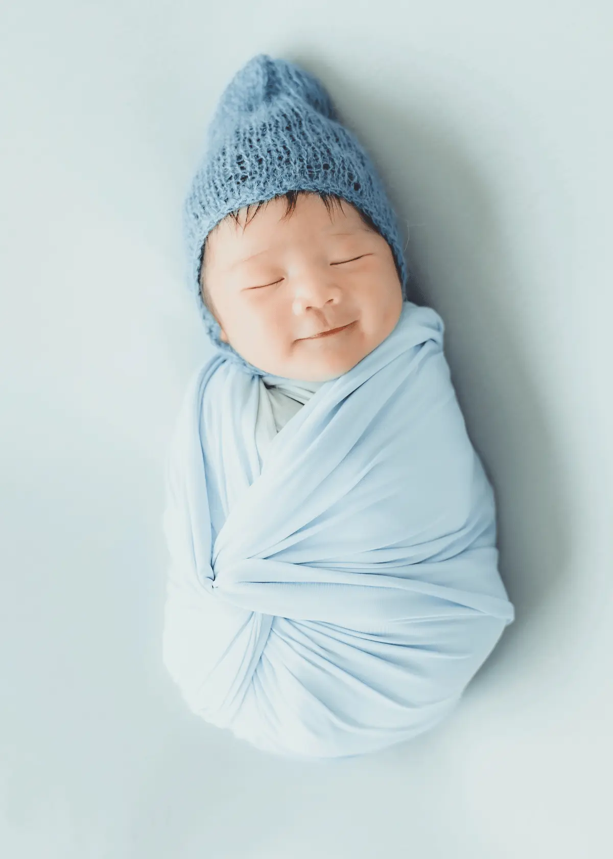Newborn baby wrapped in soft blue swaddle